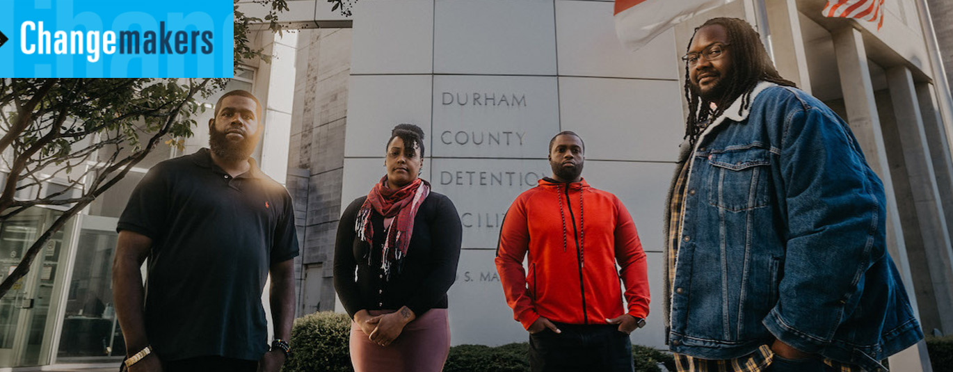 Four people helping formerly incarcerated people stand outside the Durham County Detention Facility